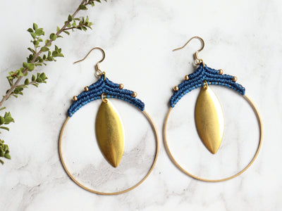 Pair Big leaf hoop macrame earrings in gold and blue color with white background.