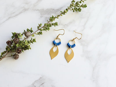 Mehndi Leaf style Drop Earrings in blue and golden color with white background.